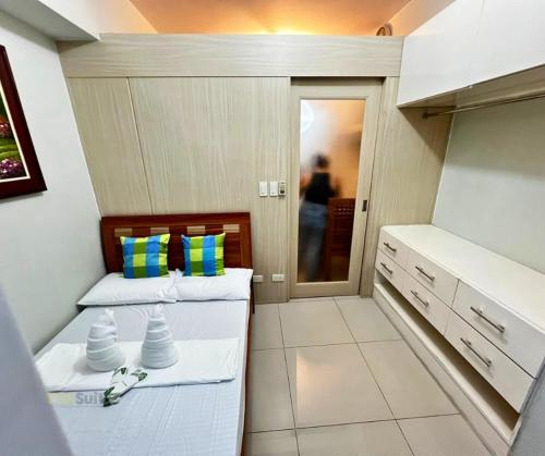 two beds in a small room with a kitchen at SM Jazz Staycation in Manila