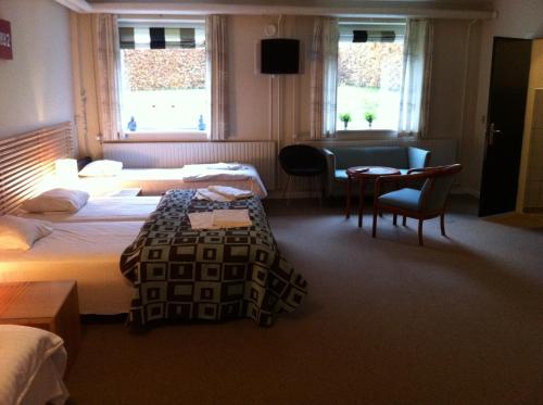 En eller flere senge i et værelse på Hotel Nørherredhus