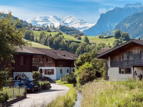 a winding road in a village with mountains in the background at Hidden Retreats 1466 Edition in Reichenbach