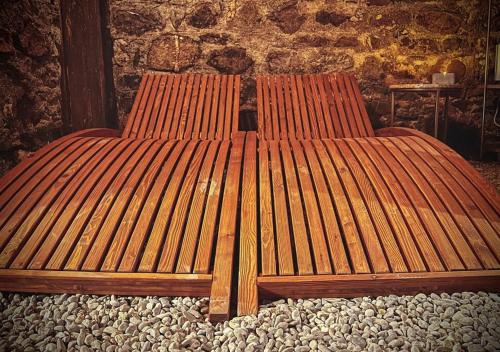 a wooden bench sitting in front of a stone wall at Hidden Retreats 1466 Edition in Reichenbach