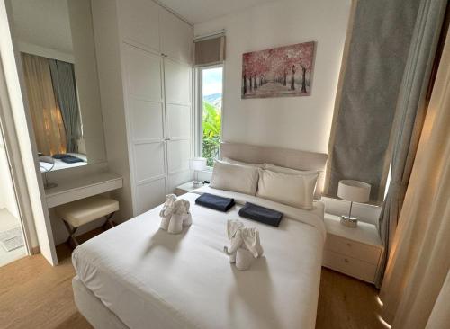 a bedroom with a bed with two stuffed animals on it at Luxury villa Kamala Garden View by Lofty in Kamala Beach