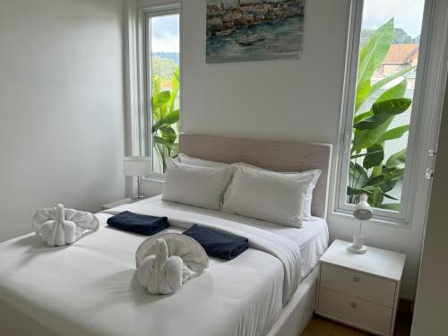 a white bed with two towels on it with a window at Luxury villa Kamala Garden View by Lofty in Kamala Beach