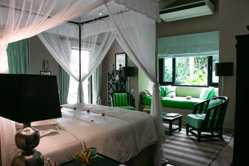 a bedroom with a canopy bed and a living room at Kahanda Kanda in Koggala