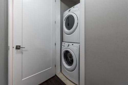 a white washer and dryer in a white room at Peaceful 2 Bedroom Suite that sleeps 4 with Free Wifi ,Free parking,easily accessible to Downtown Vancouver in Surrey