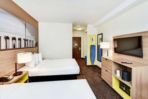 a hotel room with two beds and a flat screen tv at Days Inn by Wyndham Washington DC/Connecticut Avenue in Washington