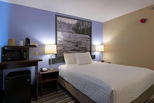 a hotel room with a bed and a television at Super 8 by Wyndham Kamloops On The Hill in Kamloops