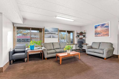 a living room with two couches and a table at Days Inn by Wyndham Sioux Falls in Sioux Falls