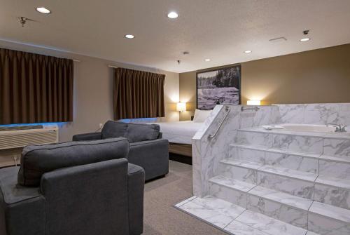 a hotel room with a bed and a tub and a bedroom at Super 8 by Wyndham Kamloops On The Hill in Kamloops
