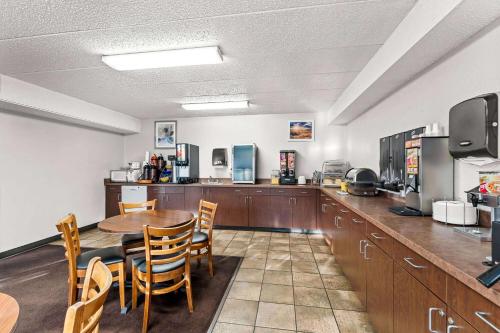 a kitchen and dining room with a table and chairs at Days Inn by Wyndham Sioux Falls in Sioux Falls