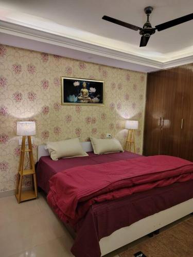 a bedroom with a large red bed with two lamps at Nilay - Fully Independent - Couple Friendly in Dehradun