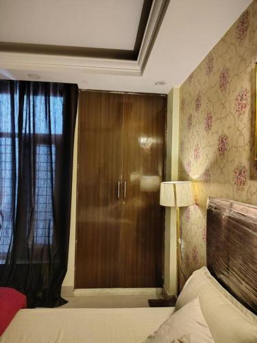 a bedroom with a wooden door and a window at Nilay - Fully Independent - Couple Friendly in Dehradun