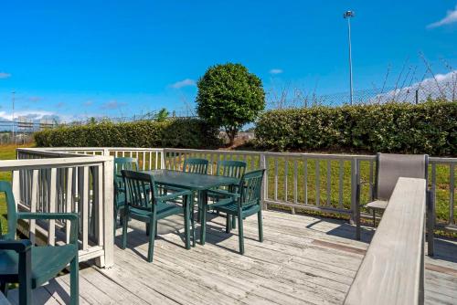 a wooden deck with a table and chairs on it at Comfort Suites Hattiesburg near University in Hattiesburg
