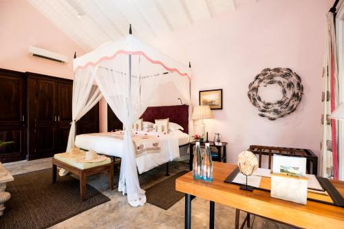 a bedroom with a bed with an umbrella at Kahanda Kanda in Koggala