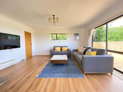 a living room with a couch and a table at Seaview house in Howick Auckland in Auckland
