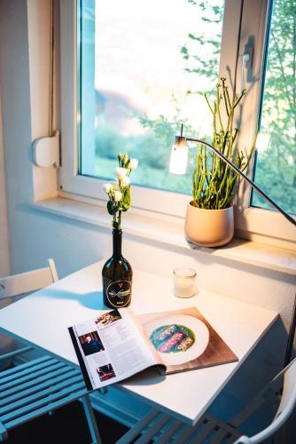a table with a book and a vase with flowers at Auszeit am Weinhof in Loschenthal