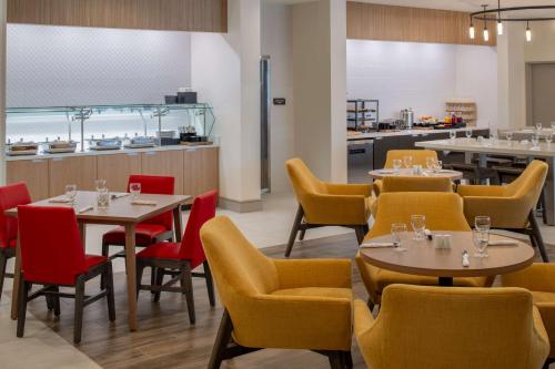 a restaurant with tables and chairs and a kitchen at Hilton Garden Inn Tacoma Downtown in Tacoma