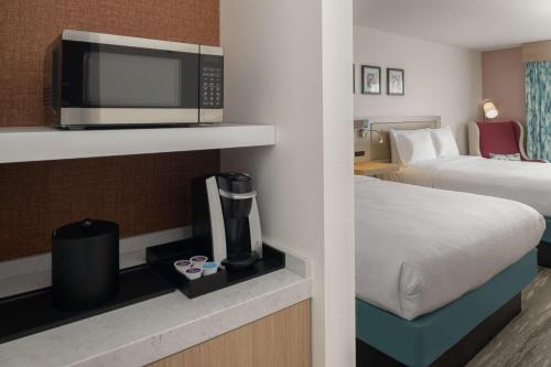 a hotel room with a bed and a microwave at Hilton Garden Inn Tacoma Downtown in Tacoma