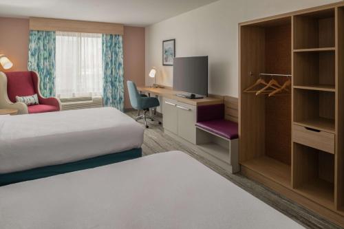 a hotel room with a bed and a desk with a tv at Hilton Garden Inn Tacoma Downtown in Tacoma