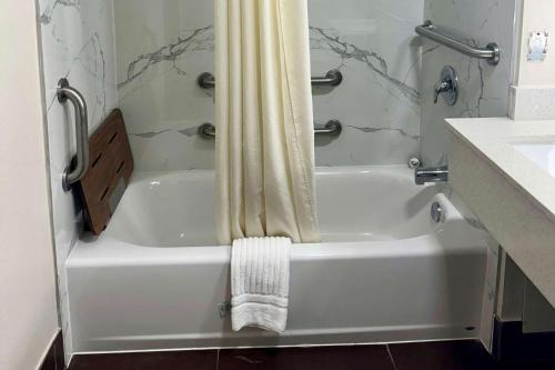 a white bath tub with a shower curtain in a bathroom at Quality Inn in Sulphur