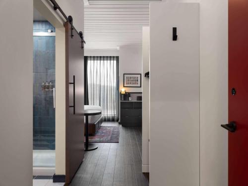 a hallway with a bathroom with a shower and a table at Origin Kansas City Riverfront, a Wyndham Hotel in Kansas City