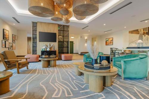 a hotel lobby with furniture and a flat screen tv at Cambria Hotel El Centro - Imperial in El Centro