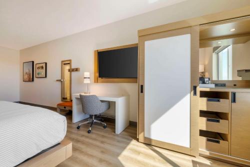 a bedroom with a bed and a desk with a computer at Cambria Hotel El Centro - Imperial in El Centro