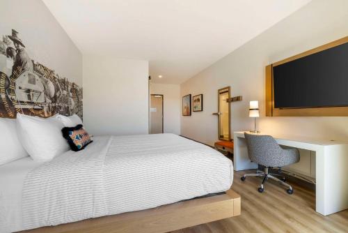 a bedroom with a bed and a desk and a television at Cambria Hotel El Centro - Imperial in El Centro