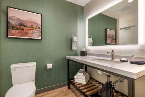 a bathroom with a sink and a toilet and a mirror at Cambria Hotel El Centro - Imperial in El Centro