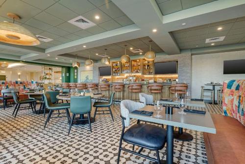 a restaurant with tables and chairs and a bar at Cambria Hotel El Centro - Imperial in El Centro