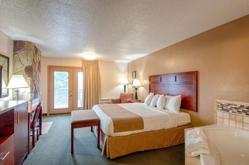 a hotel room with a bed and a bath tub at Park Tower Inn in Pigeon Forge