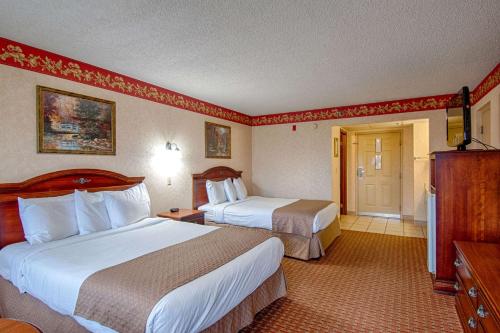 a hotel room with two beds and a television at Park Tower Inn in Pigeon Forge
