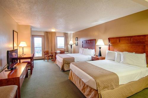 a hotel room with two beds and a television at Park Tower Inn in Pigeon Forge
