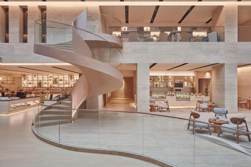 a lobby with a spiral staircase in a building at Hilton Gurugram Baani City Centre in Gurgaon