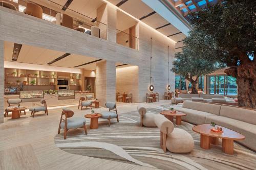 a lobby with tables and chairs in a building at Hilton Gurugram Baani City Centre in Gurgaon