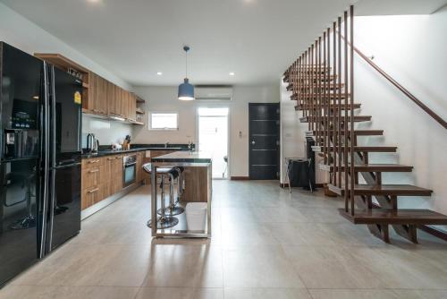 a kitchen with a spiral staircase in a house at AP Grand Residence by Lofty in Kamala Beach