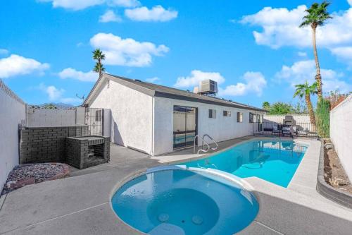 a swimming pool in front of a house with palm trees at Vegas Bliss near The Strip - Pet & Family Friendly in Las Vegas