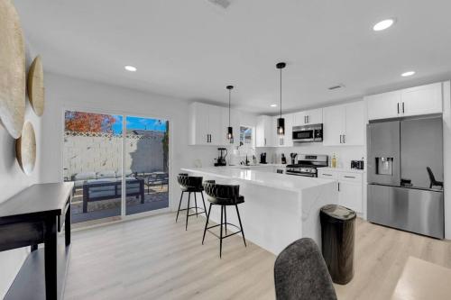 a kitchen with white cabinets and a counter with bar stools at Vegas Bliss near The Strip - Pet & Family Friendly in Las Vegas
