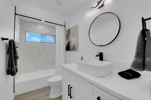 a white bathroom with a sink and a mirror at Vegas Bliss near The Strip - Pet & Family Friendly in Las Vegas