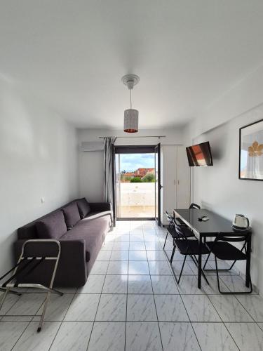 a living room with a couch and a table at Natalie's Hotel in Skala Kefalonias
