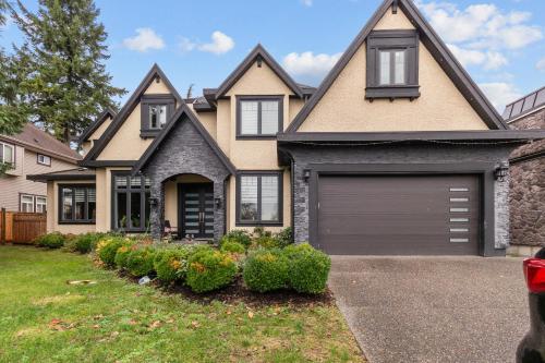 a house with a garage in the front yard at Peaceful 2 Bedroom Suite that sleeps 4 with Free Wifi ,Free parking,easily accessible to Downtown Vancouver in Surrey