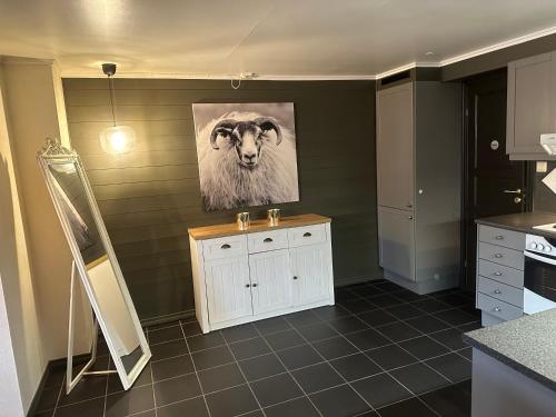 a kitchen with a painting of a sheep on the wall at Hemsedal-Toppen av Skarsnuten in Hemsedal
