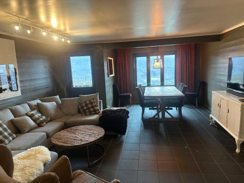 a living room with a couch and a table at Hemsedal-Toppen av Skarsnuten in Hemsedal