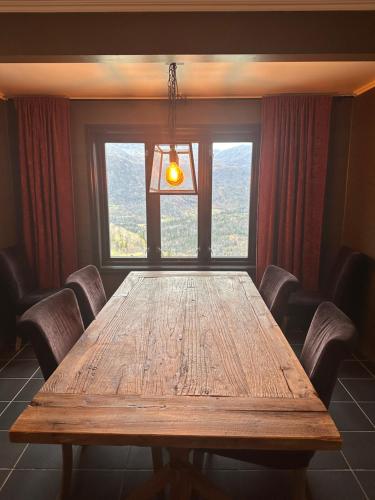a large wooden table in a room with a window at Hemsedal-Toppen av Skarsnuten in Hemsedal