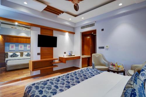 a bedroom with a bed and a flat screen tv at Hotel The Pearl, City Center - Traveler's Choice Award Winner for 2025 in New Delhi