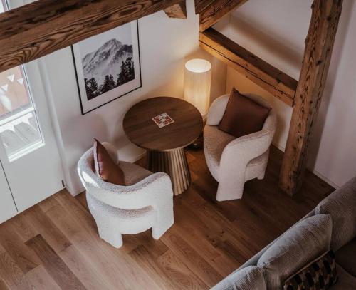 a living room with two chairs and a table at Hidden Retreats The Alpstyle in Frutigen