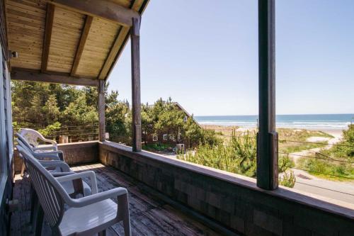 a porch with chairs and a view of the beach at Chapman Cove by AvantStay Gorgeous Beach Bungalow w Sauna in Cannon Beach