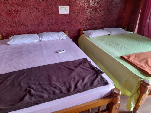 two beds sitting next to each other in a room at Aisiri comforts beach stay and cafe in Gokarn