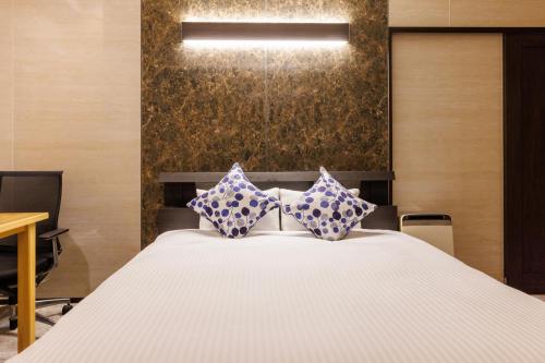 Un dormitorio con una cama con almohadas azules y blancas. en BBQ可能 露天風呂付き 麻雀 ビリヤード 卓球も可能な最大12名の一棟貸し KOEI HOUSE in KANNA, en Ginoza