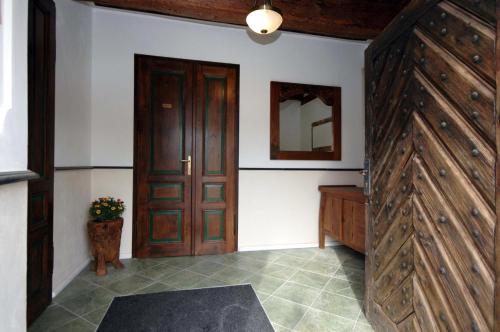 Habitación con puerta de madera y espejo. en Barokni Spejchar, en Tlučná