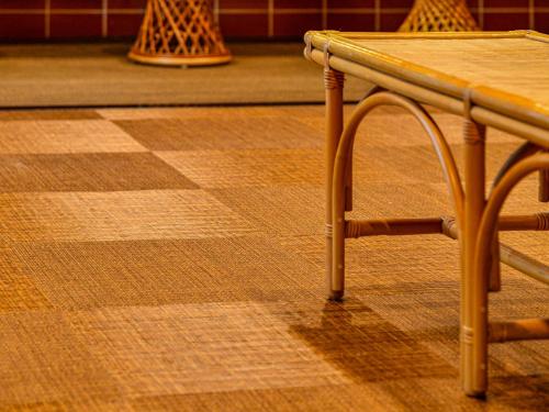 a table and a chair sitting on a checkerboard floor at Hokuriku Fukui Awara Onsen Mimatsu in Awara